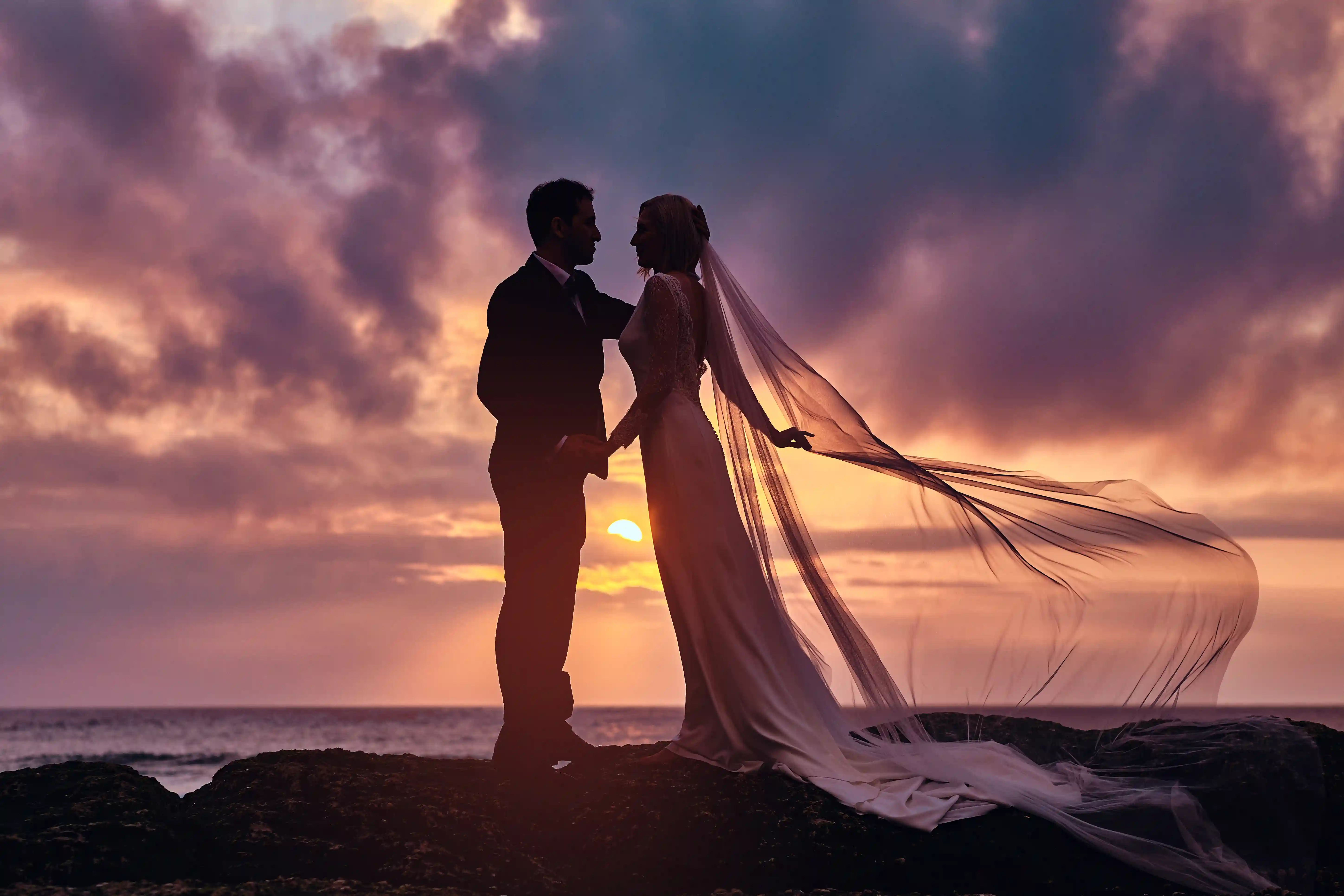 Pareja en una playa al atardecer durante su luna de miel